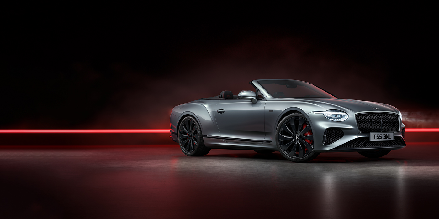 Bentley Barcelona Bentley Continental GTC Black Edition convertible front three quarters in Hallmark silver against a dark grey and red background