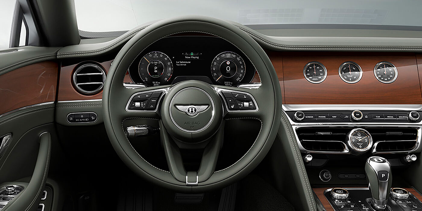 Bentley Barcelona New Bentley Flying Spur sedan front cabin in Cumbrian Green hide and Crown Cut walnut veneer showing steering wheel and Rotating Display with three clocks on face