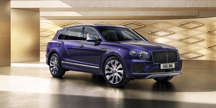 Bentley Barcelona Bentley Bentayga Extended Wheelbase Mulliner SUV front three quarter in Tanzanite Purple paint with a gold patterned background