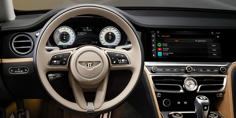 Bentley Barcelona Bentley Flying Spur Mulliner sedan front interior detail of steering wheel and driver screens surrounded by Linen and Beluga black hides