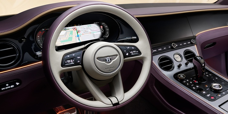 Bentley Barcelona Bentley Continental GT Mulliner coupe front interior showing steering wheel and drivers screens surrounded by Linen and Damson hides and Grand Black veneer